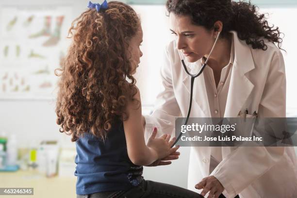 hispanic doctor examining patient - concentration curl stock pictures, royalty-free photos & images