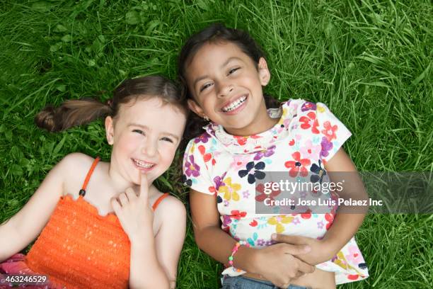 girls laying in grass - kid lying down stock pictures, royalty-free photos & images