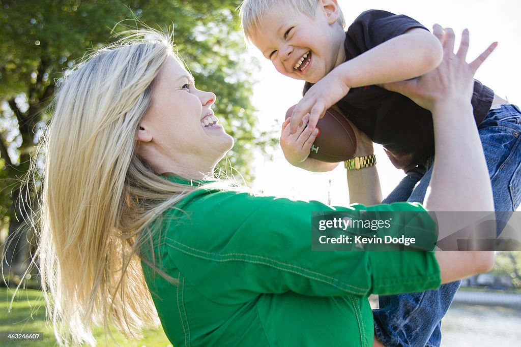 Caucasian woman playing with son