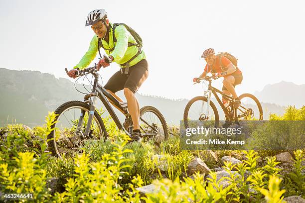 caucasian men riding mountain bikes on trail - extreme sports bike stock pictures, royalty-free photos & images
