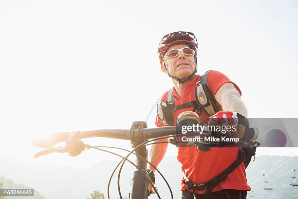 caucasian man pushing mountain bike - vitaliteit fiets stockfoto's en -beelden