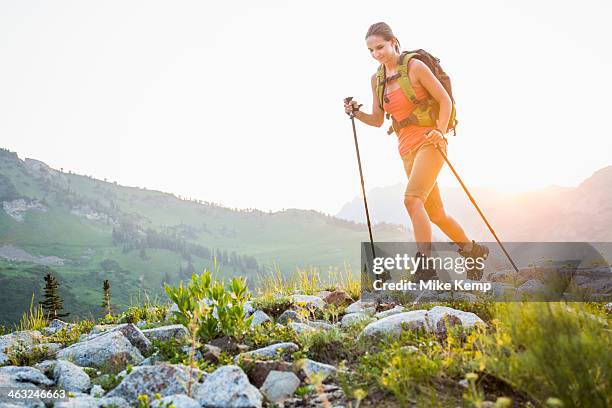 caucasian woman hiking on rocky trail - nordic walking summer stock pictures, royalty-free photos & images