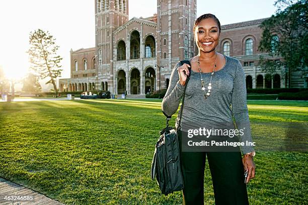 african american professor smiling on campus - portrait of teacher and student stockfoto's en -beelden