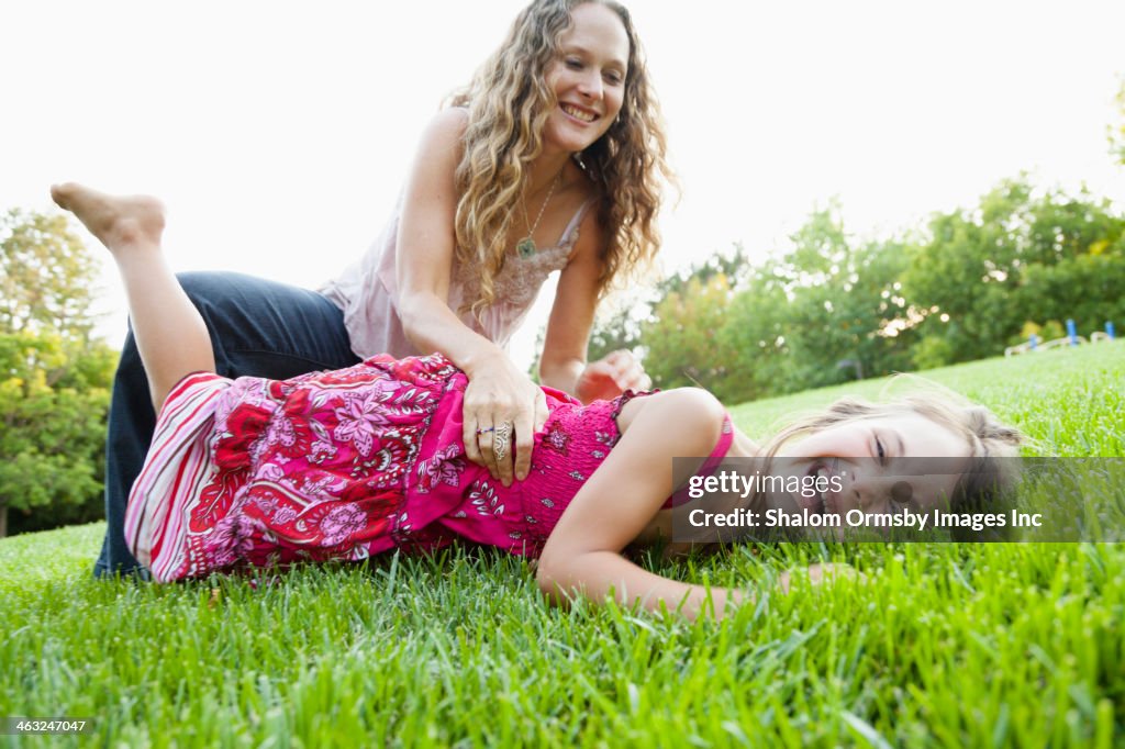 Mother and daughter playing in grass