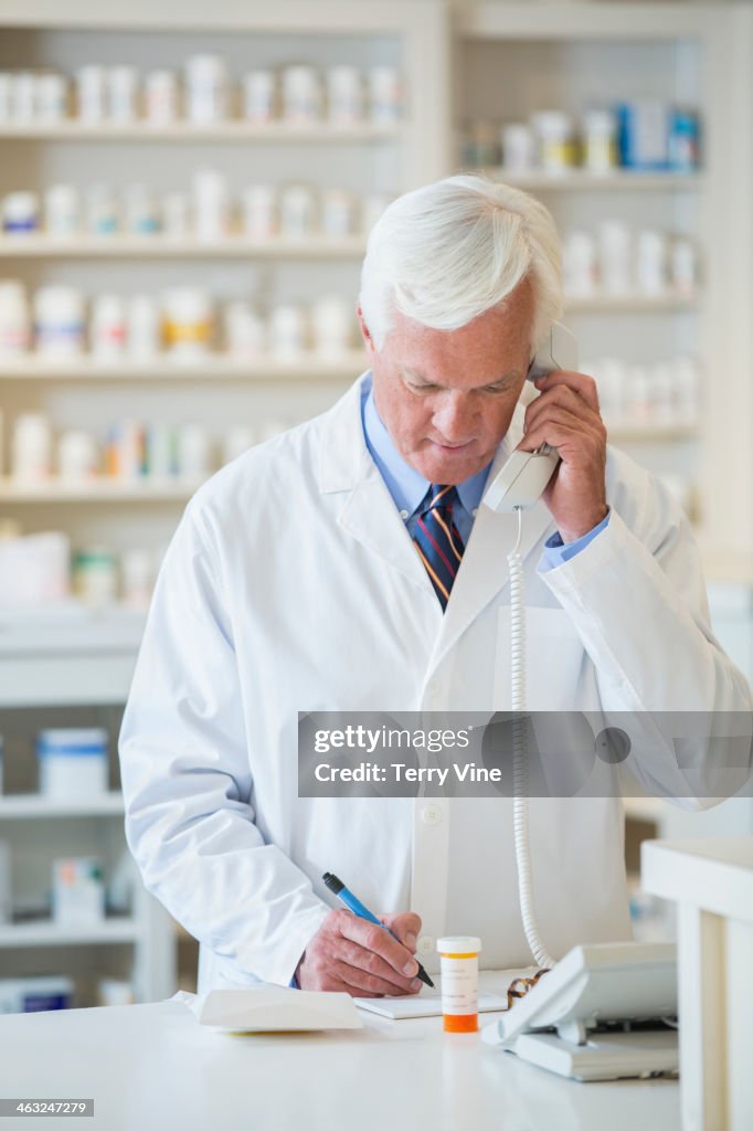 Caucasian pharmacist talking on phone