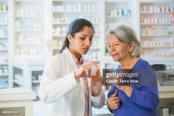 pharmacist talking to customer - pharmacist foto e immagini stock