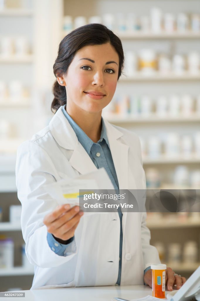 Mixed race pharmacist giving prescription to customer