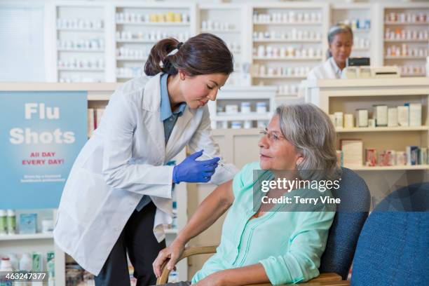 pharmacist giving customer flu shot - receiving treatment concerned stock pictures, royalty-free photos & images