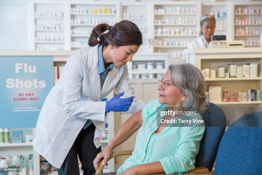 Pharmacist giving customer flu shot