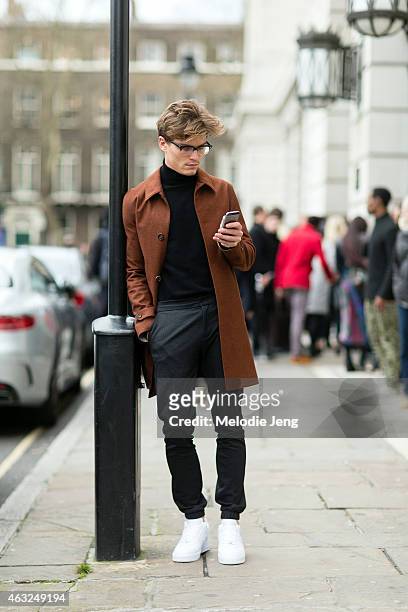 Model Oliver Cheshire wears an Aquascutum jacket, Topman trousers, and Nike Air Force 1 trainers at the London Collections: Men AW15 at on January...