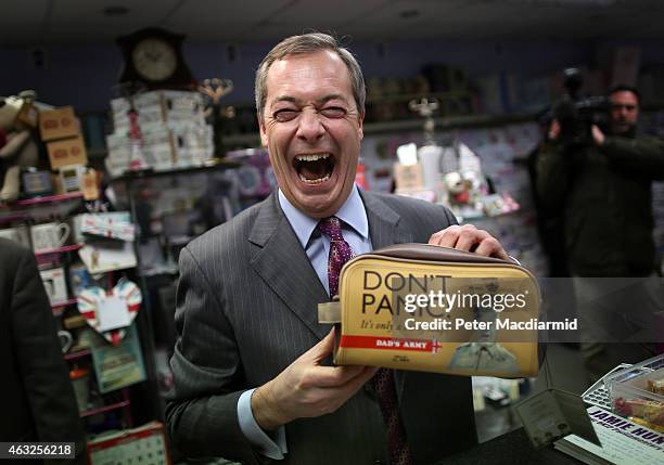 United Kingdom Indepedence Party leader Nigel Farage smiles as he holds a wash bag with writing on which reads 'Don't Panic' as he campaigns ahead of...