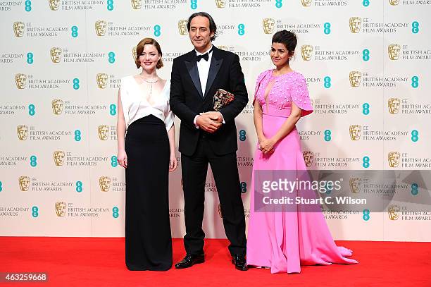 Alexandre Desplat , winner of the Original Music award for 'The Grand Budapest Hotel', poses with presenters Holliday Grainger and Nimrat Kaur in the...