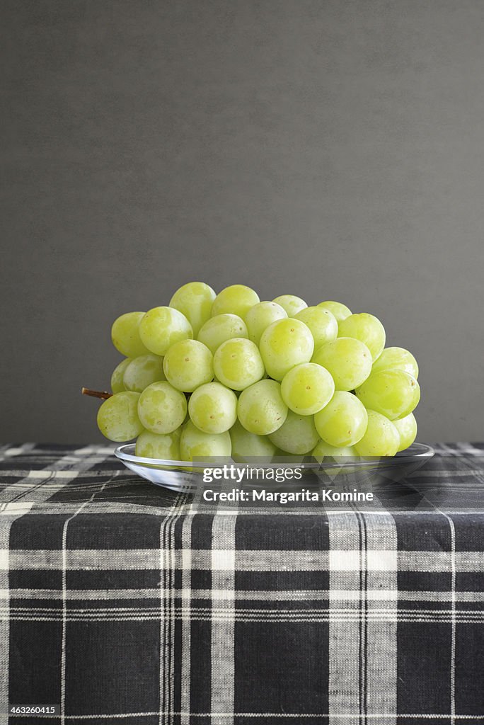 Green grapes on a glass plate
