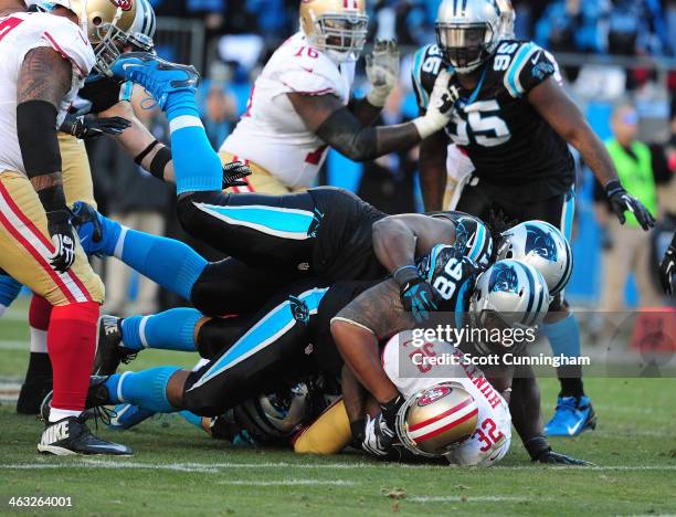 Kendall Hunter of the San Francisco 49ers is tackled during the NFC Divisional Playoff Game by Luke Kuechly, Colin Cole, and Star Lotulelei of the...