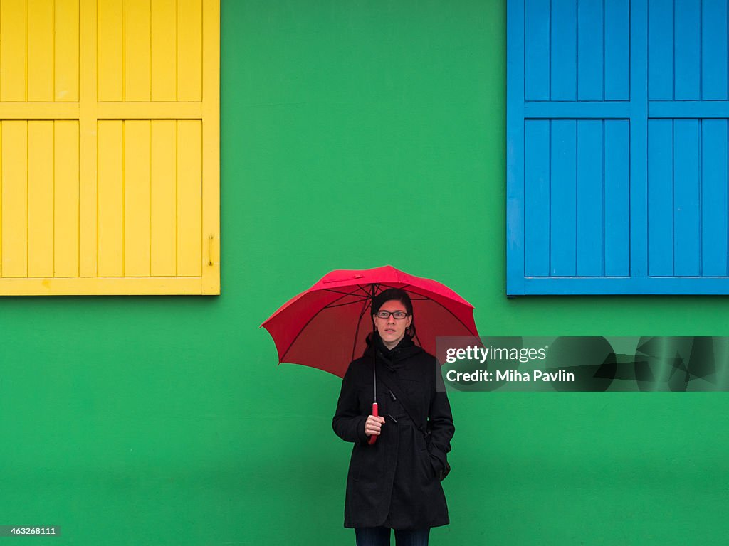 Red umbrella against colorful wall