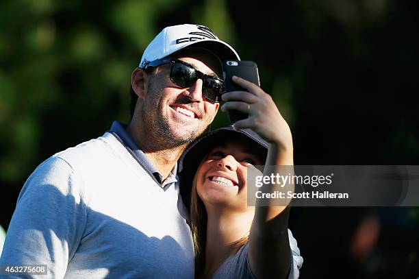 Country music star Jake Owen poses with a fan during the first round of the AT&T Pebble Beach National Pro-Am at Monterey Peninsula Country Club on...