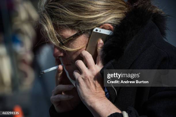 Woman smokes a cigarette on January 17, 2014 in Times Square in New York City. A new report from the Surgeon General shows the that list of negative...
