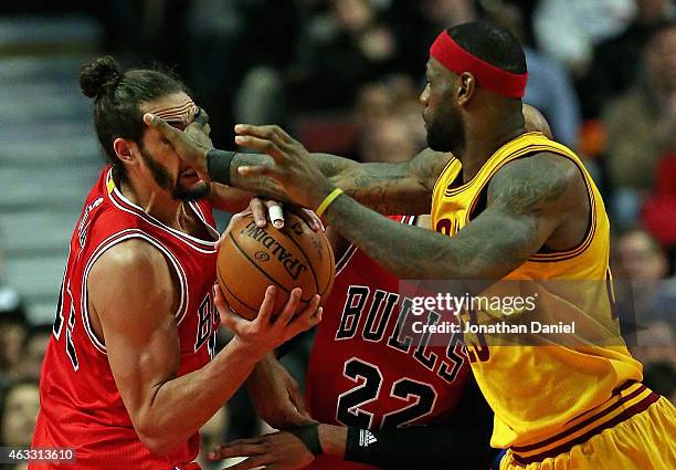 LeBron James of the Cleveland Cavaliers fouls Joakim Noah of the Chicago Bulls at the United Center on February 12, 2015 in Chicago, Illinois. The...