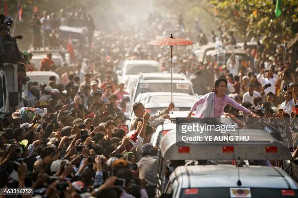 Myanmar opposition leader Aung San Suu Kyi greets supporters as she leaves a ceremony to mark the 100th birthday of independence hero Aung San, in...