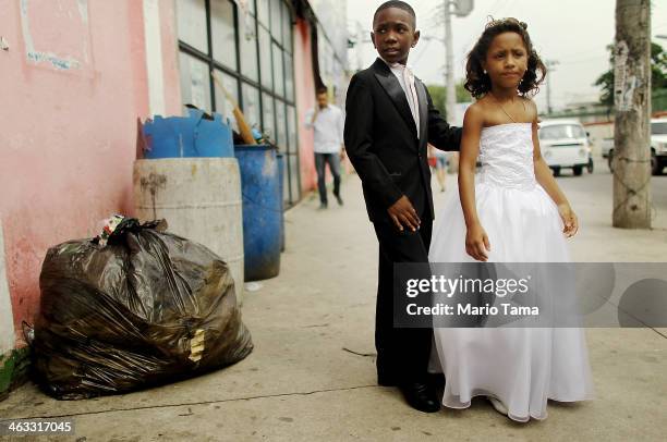 Young family members wait to enter a communal marriage ceremony in the Jacarezinho pacified community, or shantytown, on January 17, 2014 in Rio de...