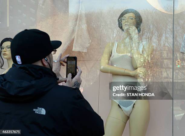 Man takes a cell phone photograph of a mannequin with pubic hair in the window of an American Apparel shop on Houston Street in the Soho section of...