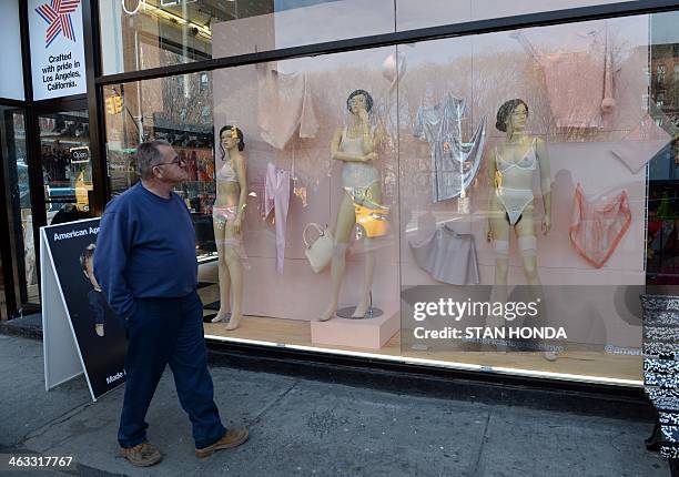 Man looks at mannequins with pubic hair in the window of an American Apparel shop on Houston Street in the Soho section of Manhattan January 17, 2014...