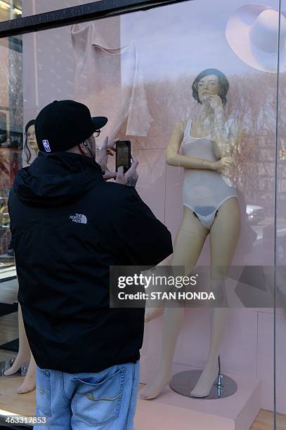 Man takes a cell phone photograph of a mannequin with pubic hair in the window of an American Apparel shop on Houston Street in the Soho section of...