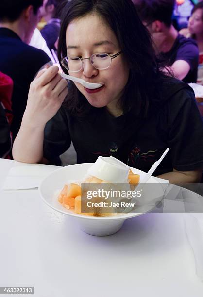 woman eating shaved mango ice - mango shaved ice stock pictures, royalty-free photos & images