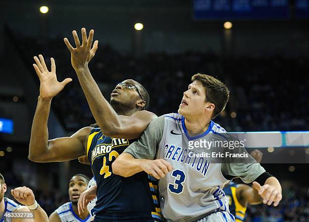 Doug McDermott of the Creighton Bluejays and Chris Otule of the Marquette Golden Eagles battle for position during their game at the CenturyLink...