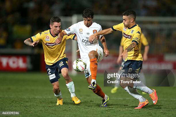 Thomas Broich of the Roar controls the ball betwen Storm Roux and Anthony Caceres of the Mariners during the round 17 A-League match between the...