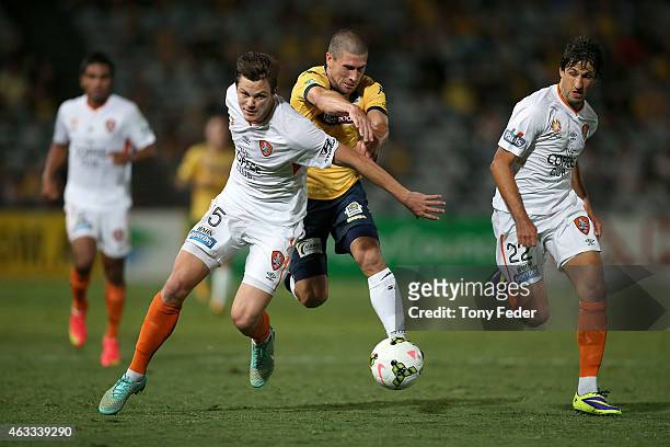 Nick Montgomery of the Mariners contests the ball with Corey Brown of the Roar during the round 17 A-League match between the Central Coast Mariners...
