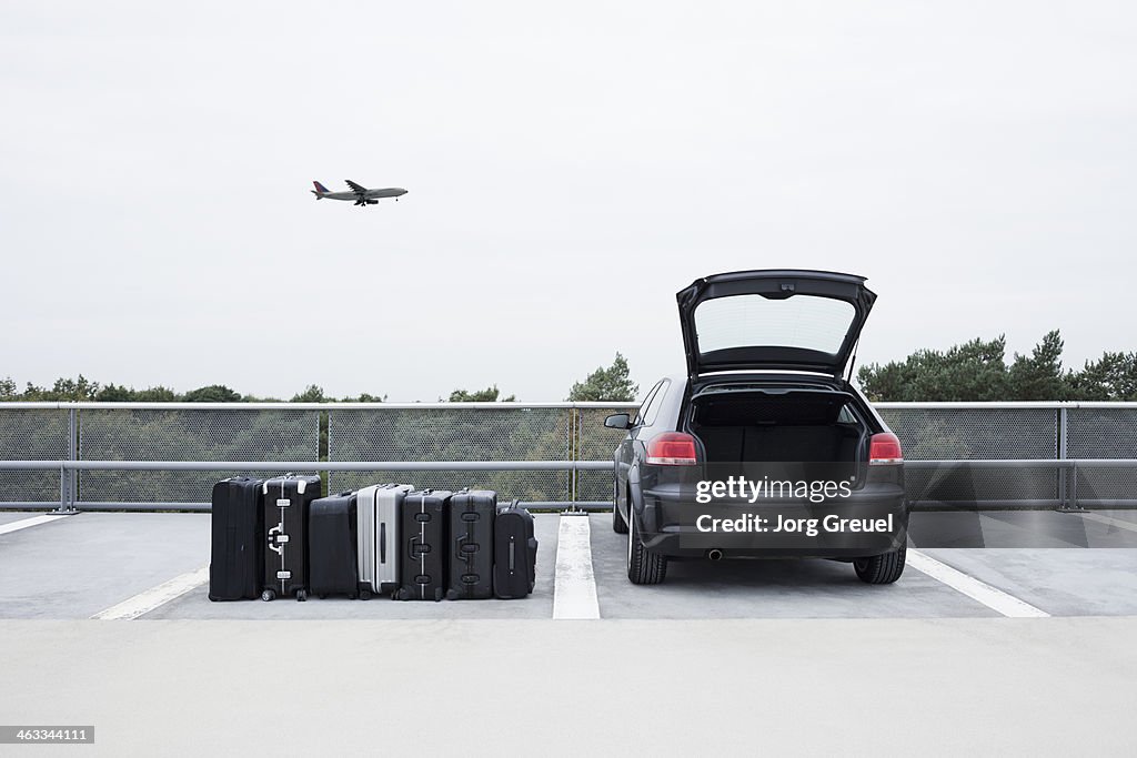 Suitcases beside car