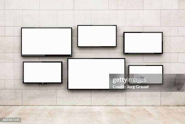 flat screens hanging on a wall - flachbildmonitor stock-fotos und bilder