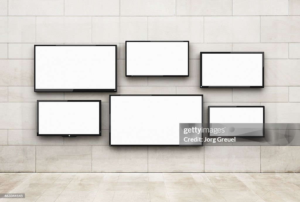 Flat screens hanging on a wall