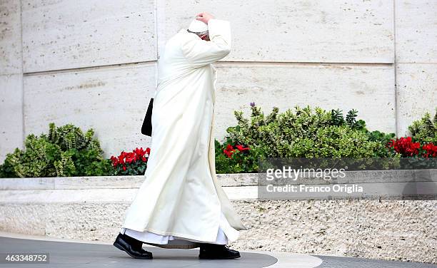 Pope Francis holds his biretta cup as he leaves the Synod Hall at the end of the Extraordinary Consistory for the creation of new cardinals on...