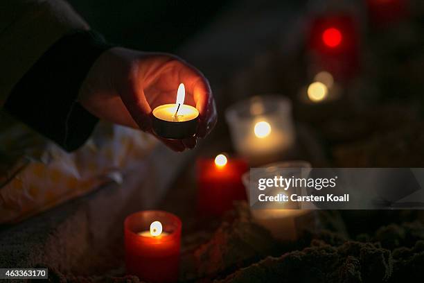 Visitor lights a candle in front of the Frauenkirche to commemorate the 70th anniversary of the Allied firebombing of Dresden on February 13, 2015 in...