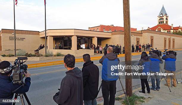 Small but growing line of trial spectators, watched by television crews, wait to enter the Erath County, Donald R. Jones Justice Center in...