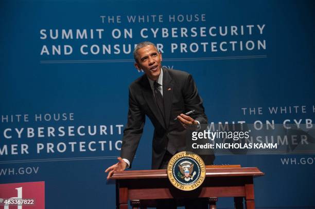 President Barack Obama signs an executive order promoting private sector cybersecurity information sharing after speaking at the White House Summit...