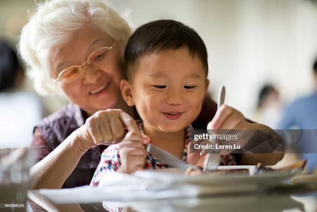 Kid learns how to use knive and fork