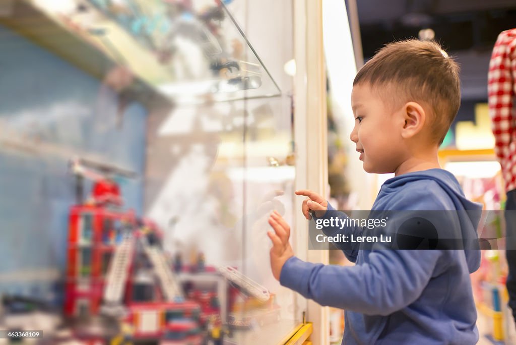 Kid looking and pointing at toys