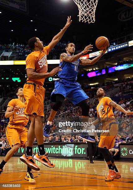 Monta Ellis of the Dallas Mavericks lays up a shot past Channing Frye and Marcus Morris of the Phoenix Suns during the first half of the NBA game at...