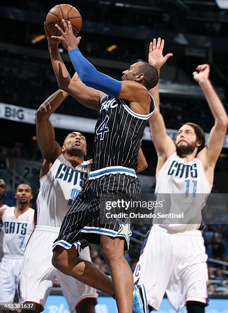 Orlando Magic guard Arron Afflalo shoots the ball between Charlotte Bobcats guard Gerald Henderson and forward Josh McRoberts during the game at the...