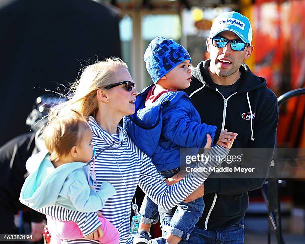 Aric Almirola, driver of the Smithfield Ford, walks through the garage area with his wife, Janice, son, Alex and daughter, Abby during practice for...