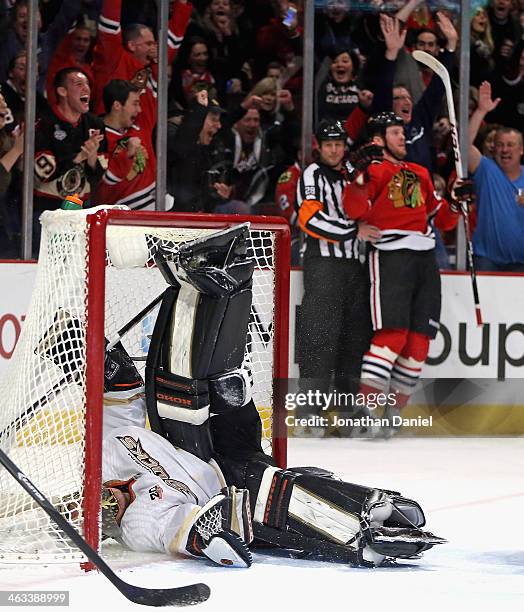Jonas Hiller of the Anaheim Ducks ends up on his back in the net after Bryan Bickell of the Chicago Blackhawks scored a goal in the third period at...