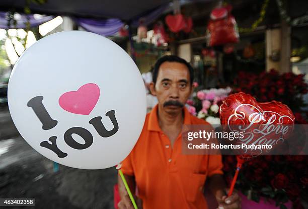 Vendor shows balloons during Valentines Day on February 14, 2015 in Surabaya, Indonesia. Roses, chocolates, teddy bears, toy hearts, candles, and...