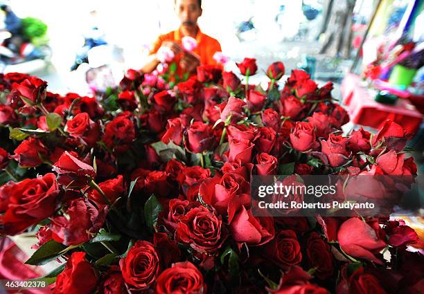 Florist prepares roses at a traditional flower market during Valentines Day on February 14, 2015 in Surabaya, Indonesia. Roses, chocolates, teddy...