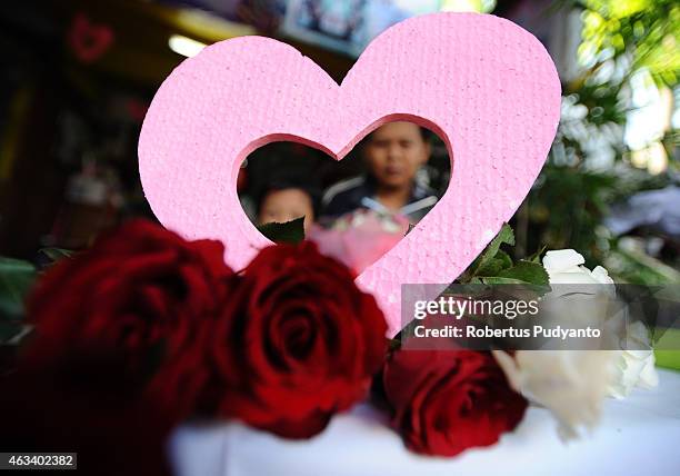 Florist prepares roses at a traditional flower market during Valentines Day on February 14, 2015 in Surabaya, Indonesia. Roses, chocolates, teddy...