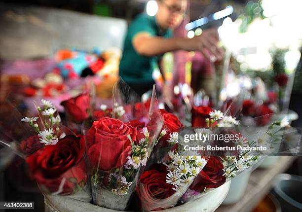 Florist prepares roses at a traditional flower market during Valentines Day on February 14, 2015 in Surabaya, Indonesia. Roses, chocolates, teddy...