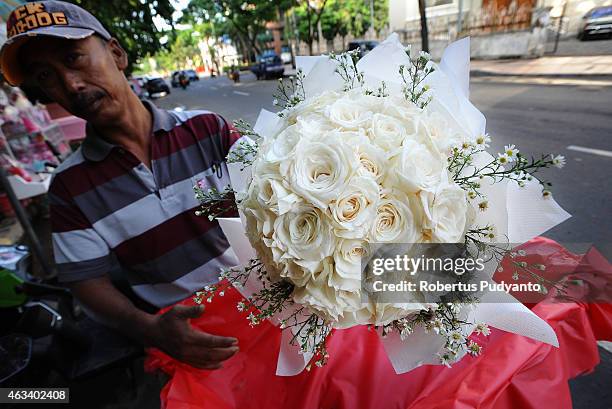 Florist prepares roses at a traditional flower market during Valentines Day on February 14, 2015 in Surabaya, Indonesia. Roses, chocolates, teddy...