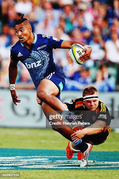 Lolagi Visinia of the Blues tries to get away from Sam Cane of the Chiefs during the round one Super Rugby match between the Blues and the Chiefs at...